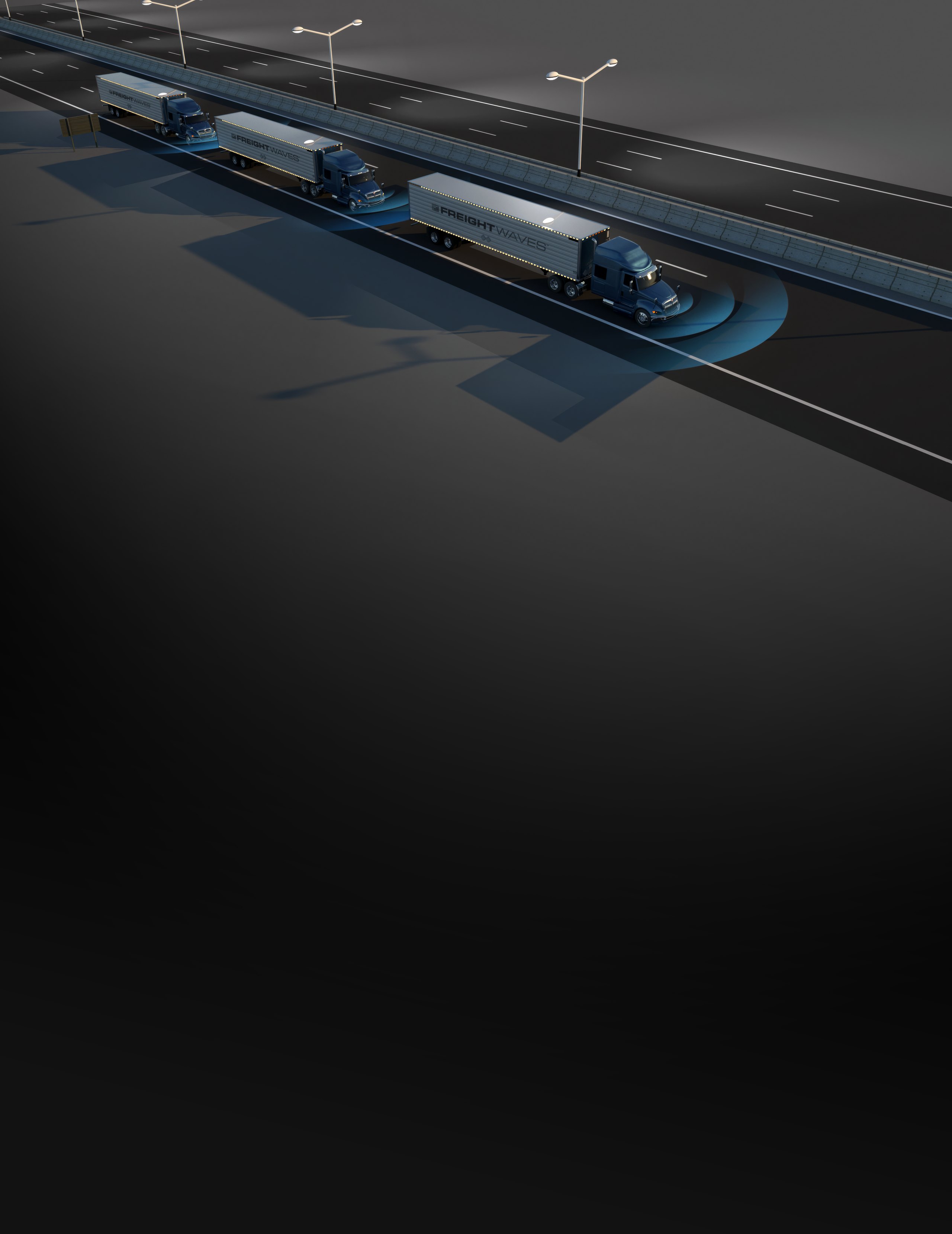 Three FreightWaves-branded tractor-trailers running in a close convoy along a highway at night